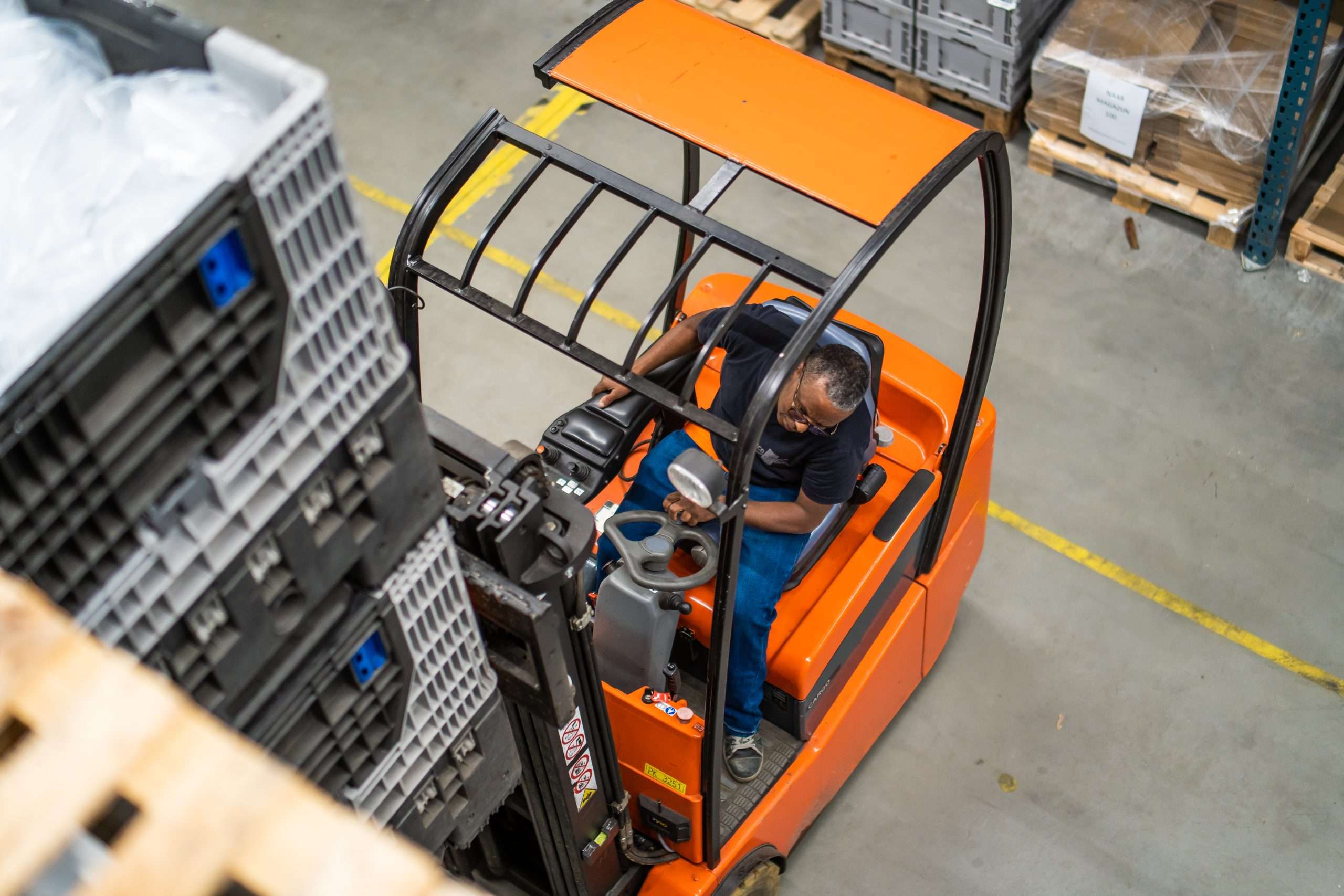 Magazijn medewerker aan het werk op heftruck