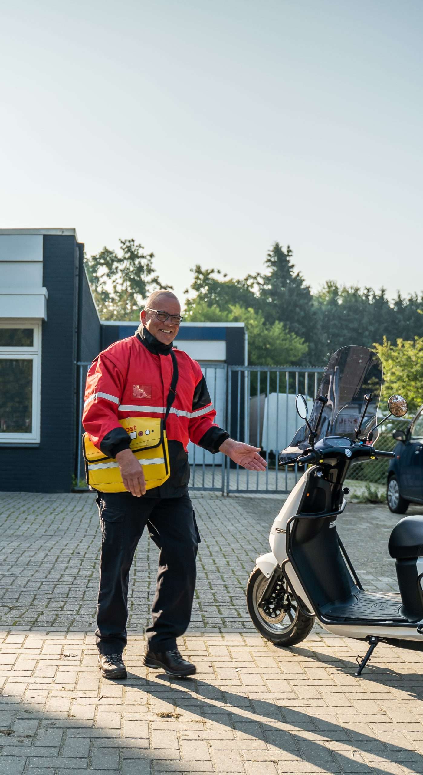 Businesspost bezorger stapt op zijn scooter