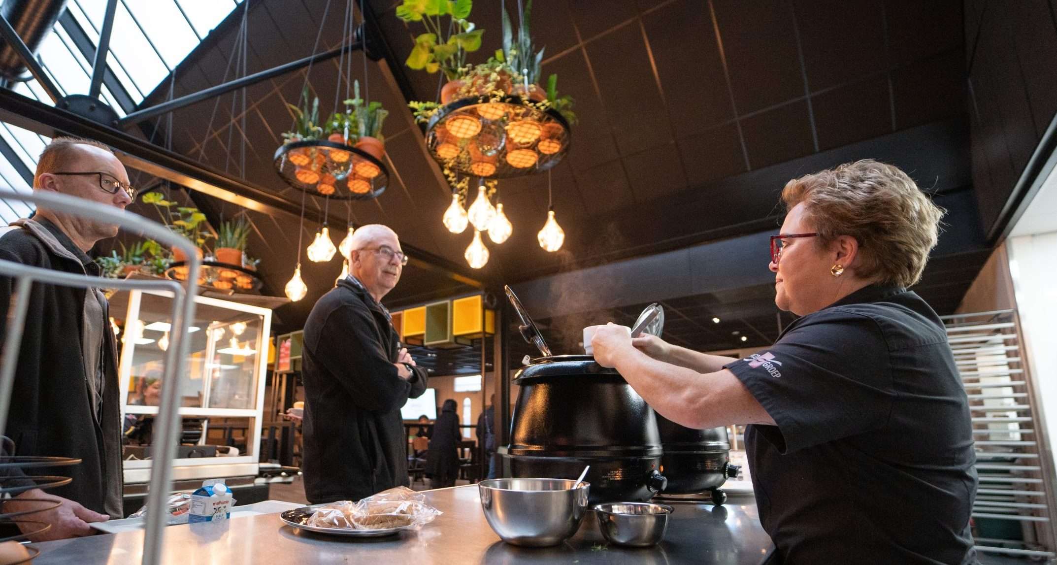 Dame serveert soep in bedrijfsrestaurant EMCO-groep