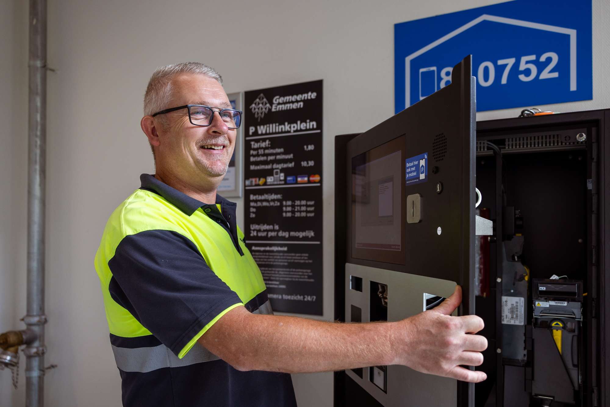 Parkeerbeheerder controleert parkeerautomaat