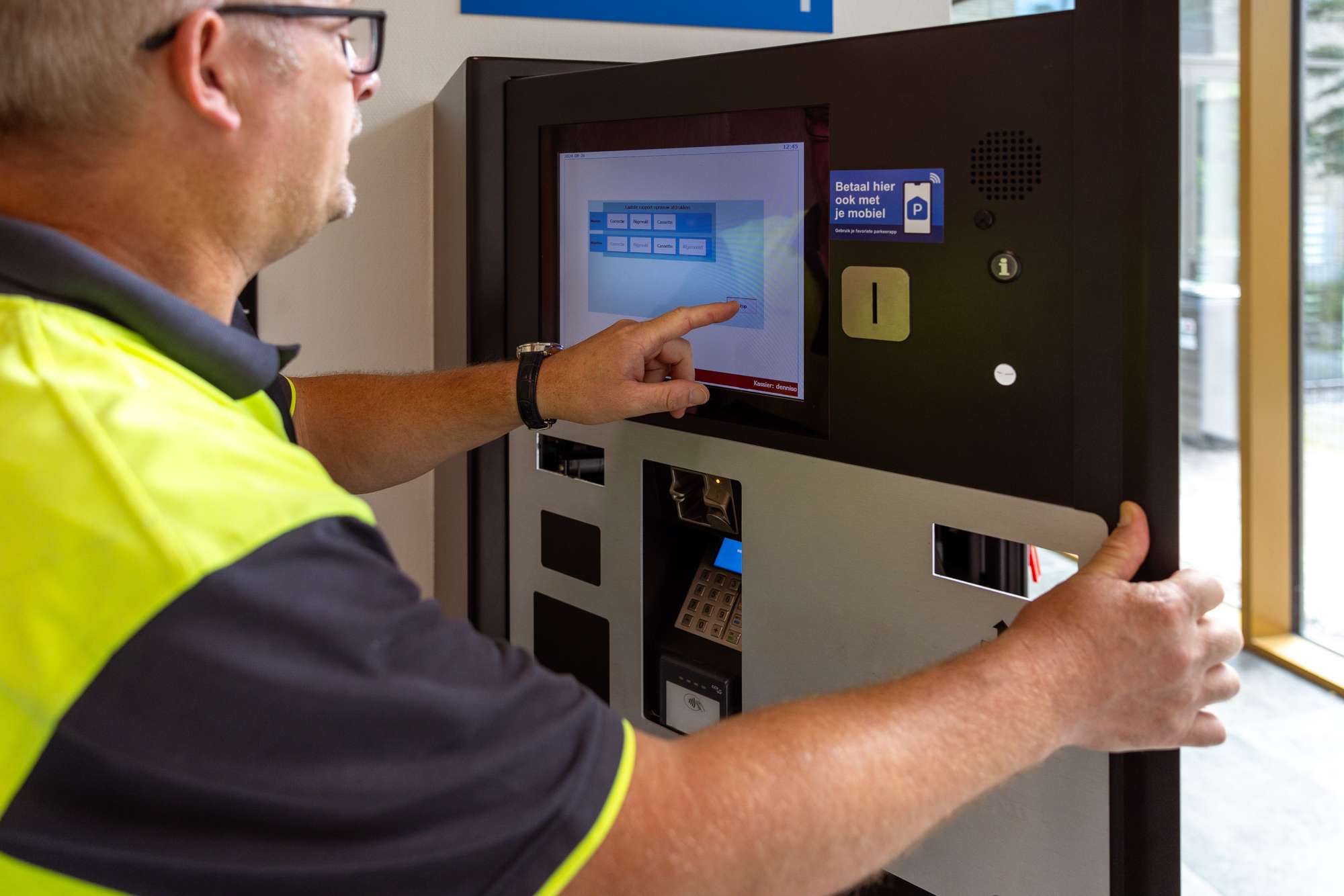 Parkeerbeheerder controleert parkeerautomaat