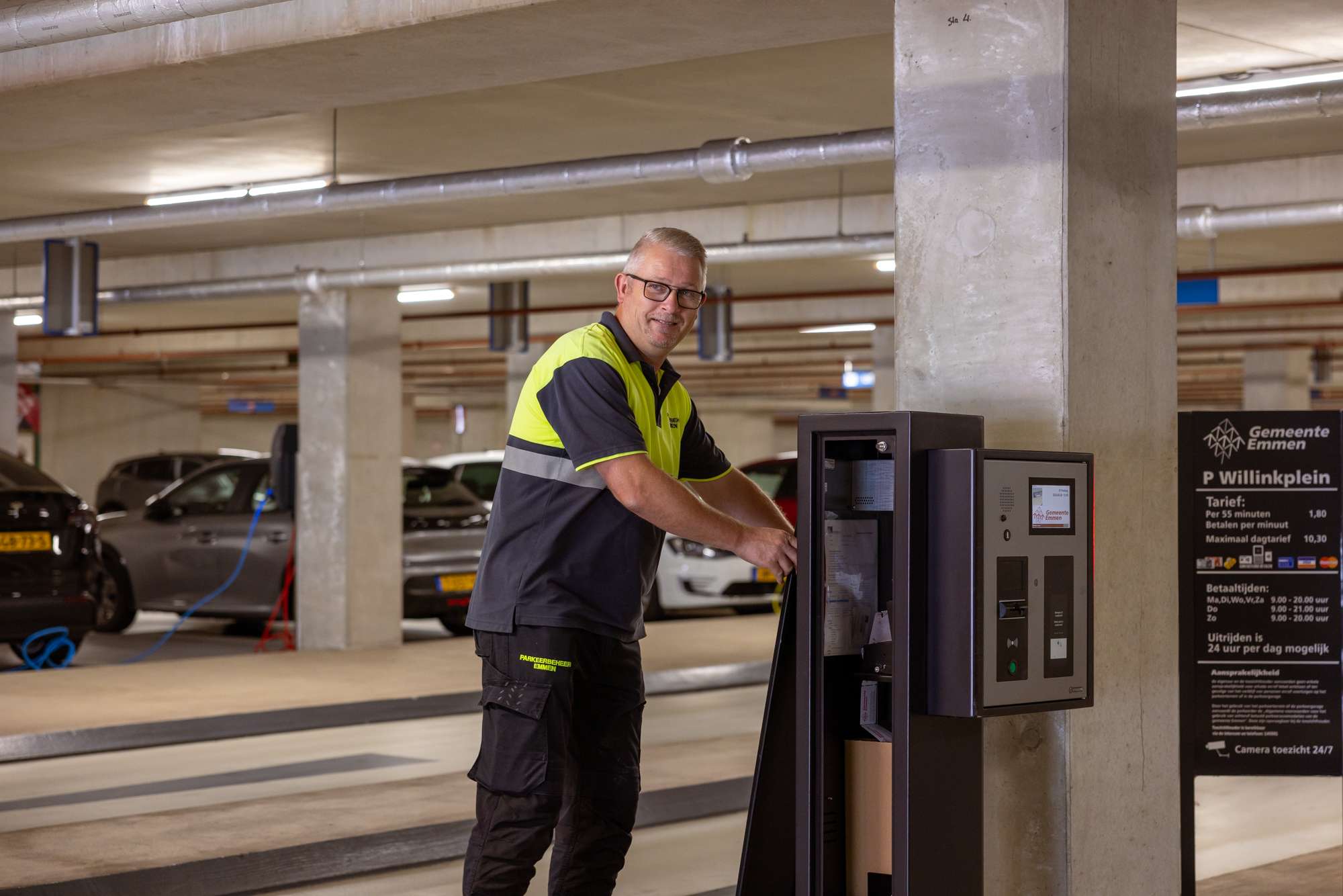 Parkeerbeheerder controleert automaat bij slagboom