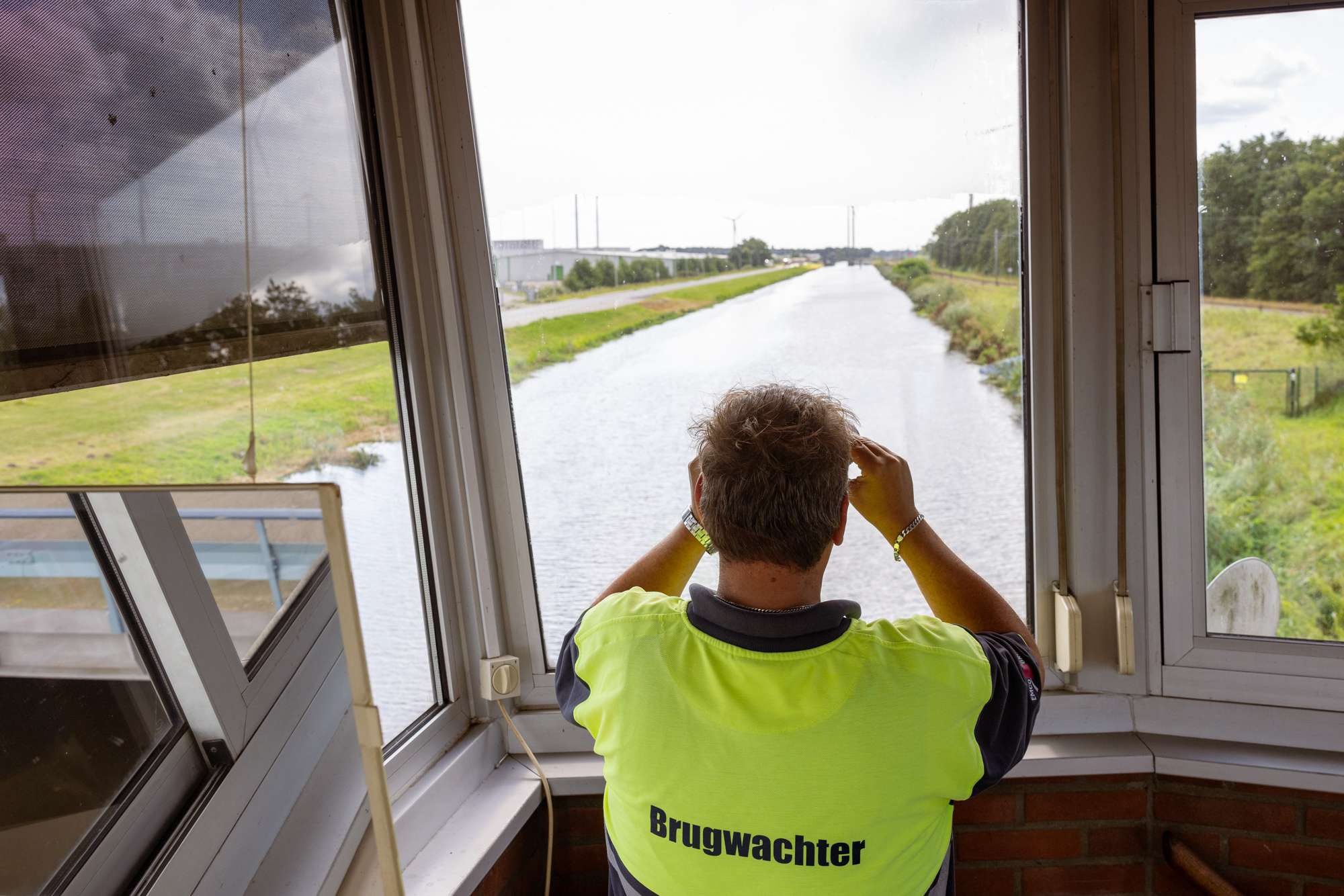 Brugwachter kijkt door verrekijker