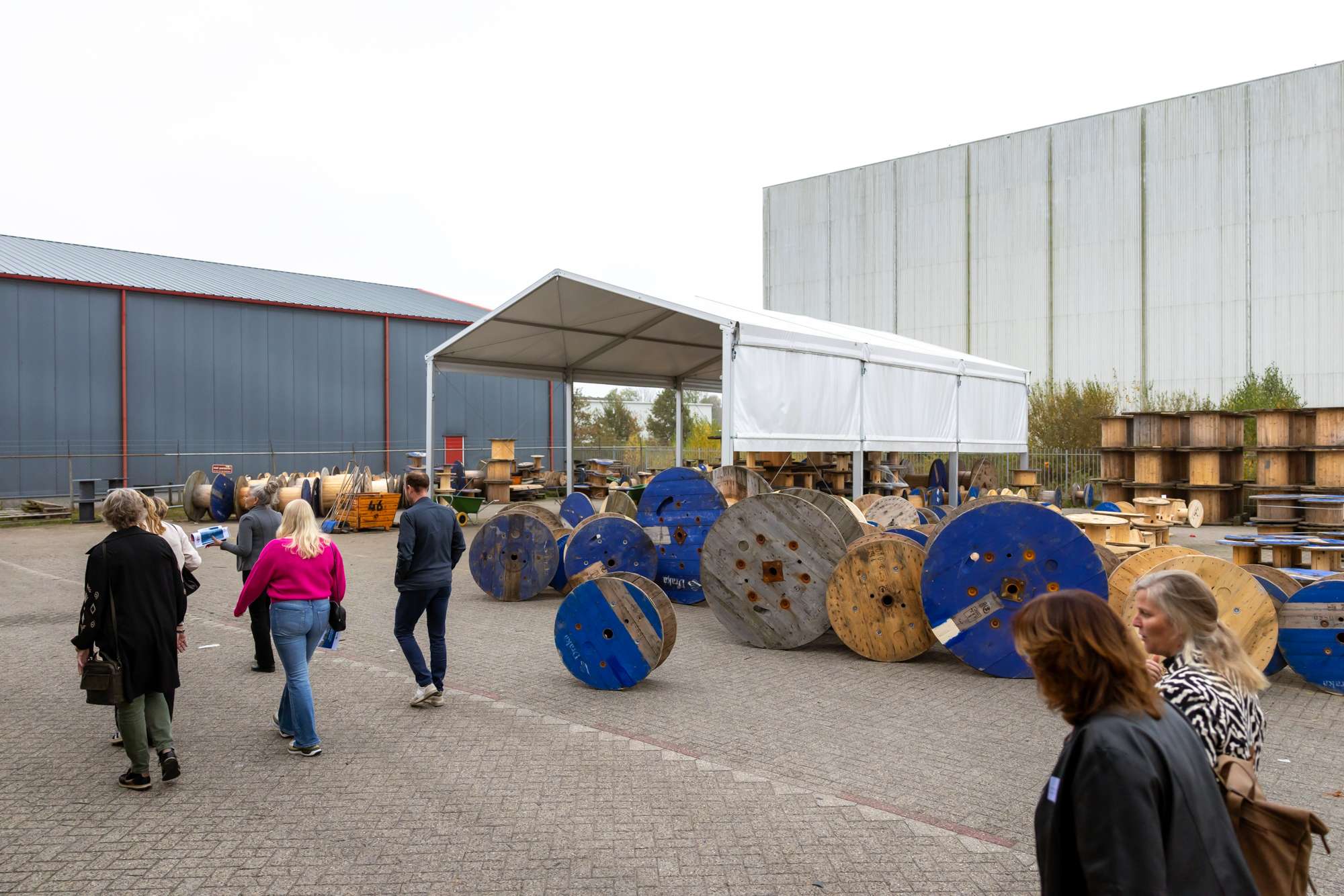 Groep mensen bij houten haspels tijdens 25 jaar jubileum