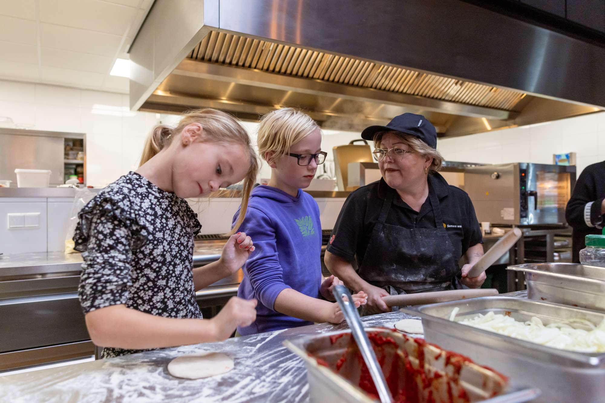 Twee kinderen aan het helpen in de keuken