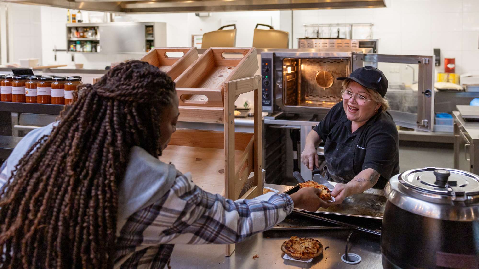 Dame krijgt eten van de kantine medewerkster tijdens open bedrijvendag