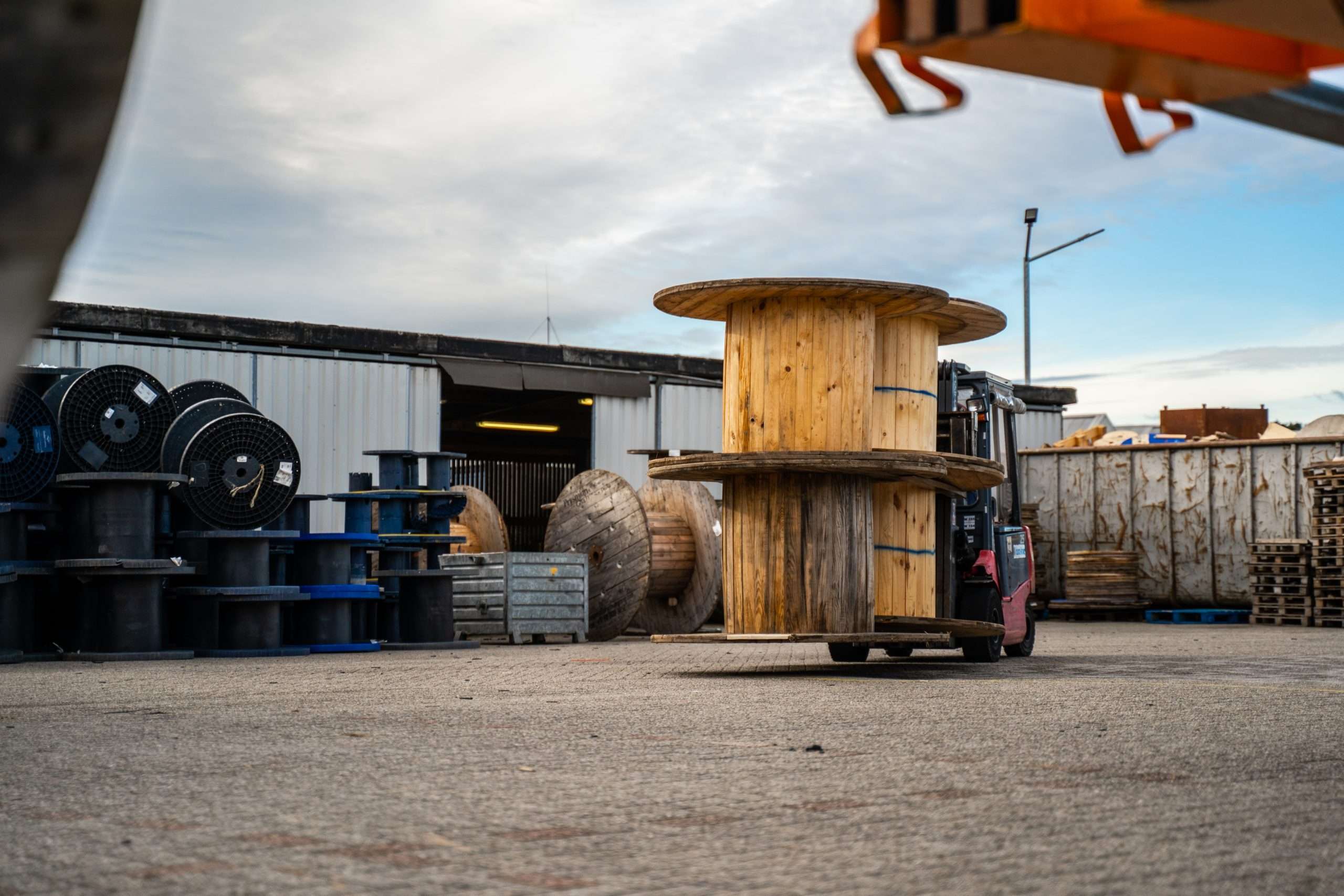 Heftruck rijdt met 4 houten haspels op buitenterrein