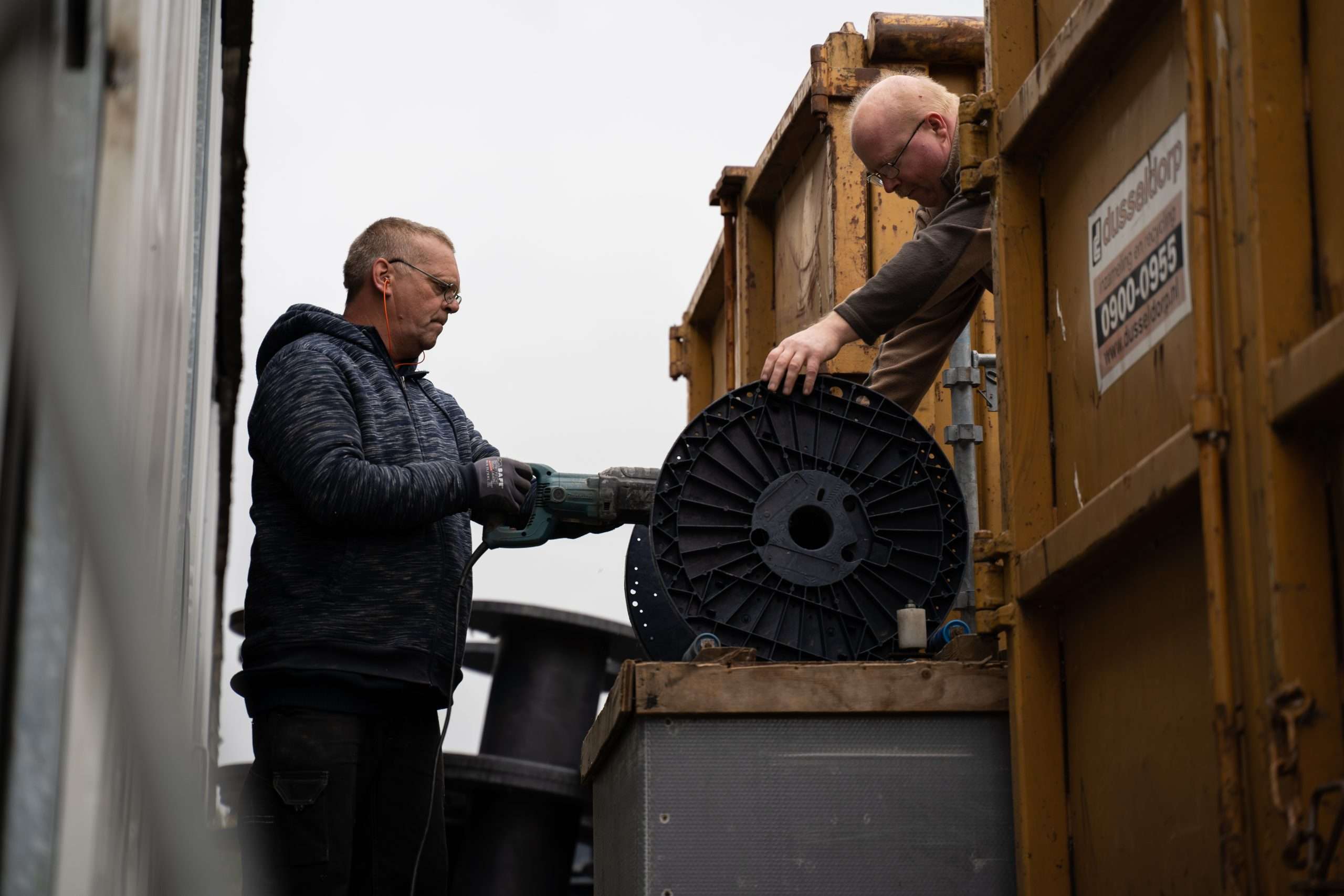 Twee mannen bezig met een kleine haspel