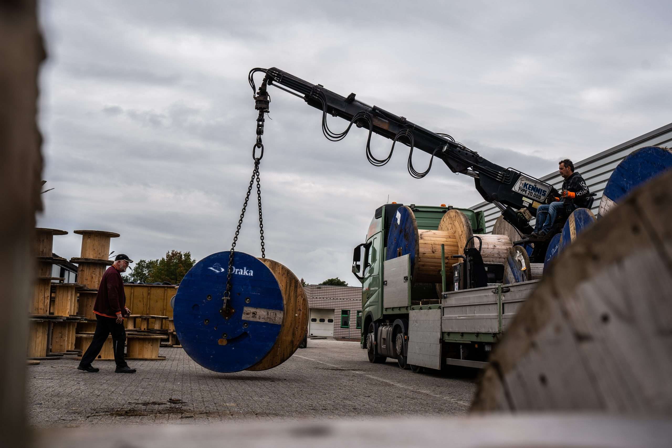 Man op kraanwagen het heffen van een haspel