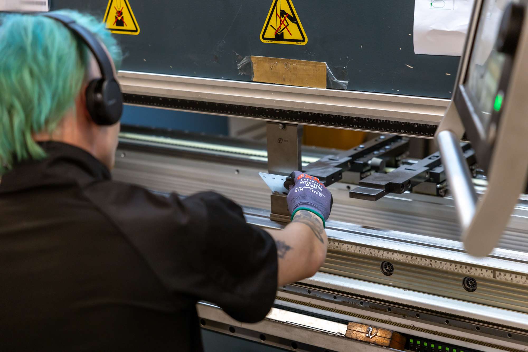 Medewerker met machine aan het werk voor metaalbewerking.