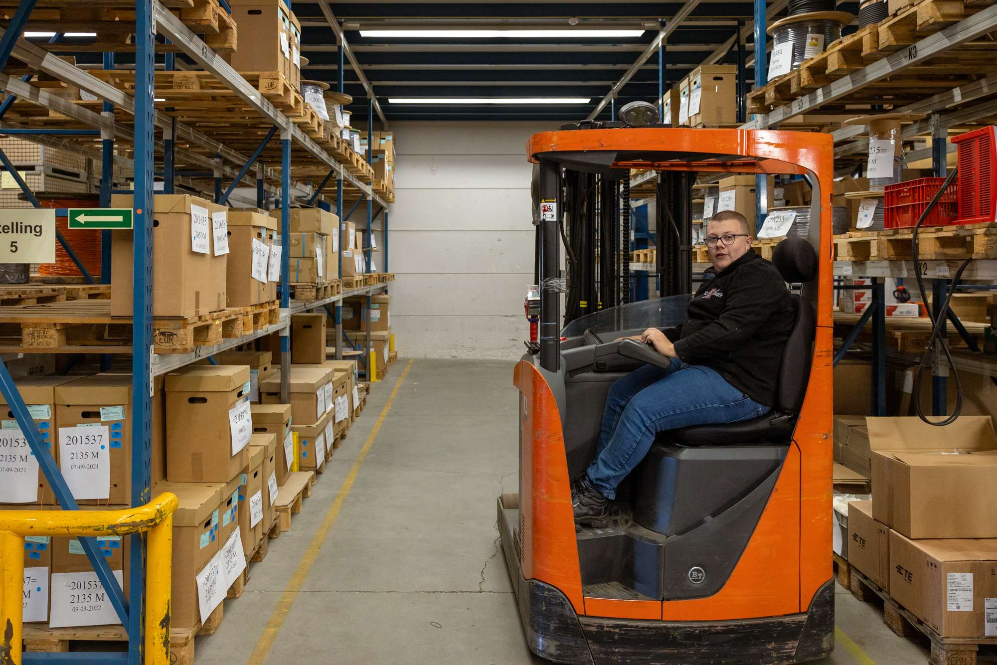 Persoon op een heftruck in een magazijn