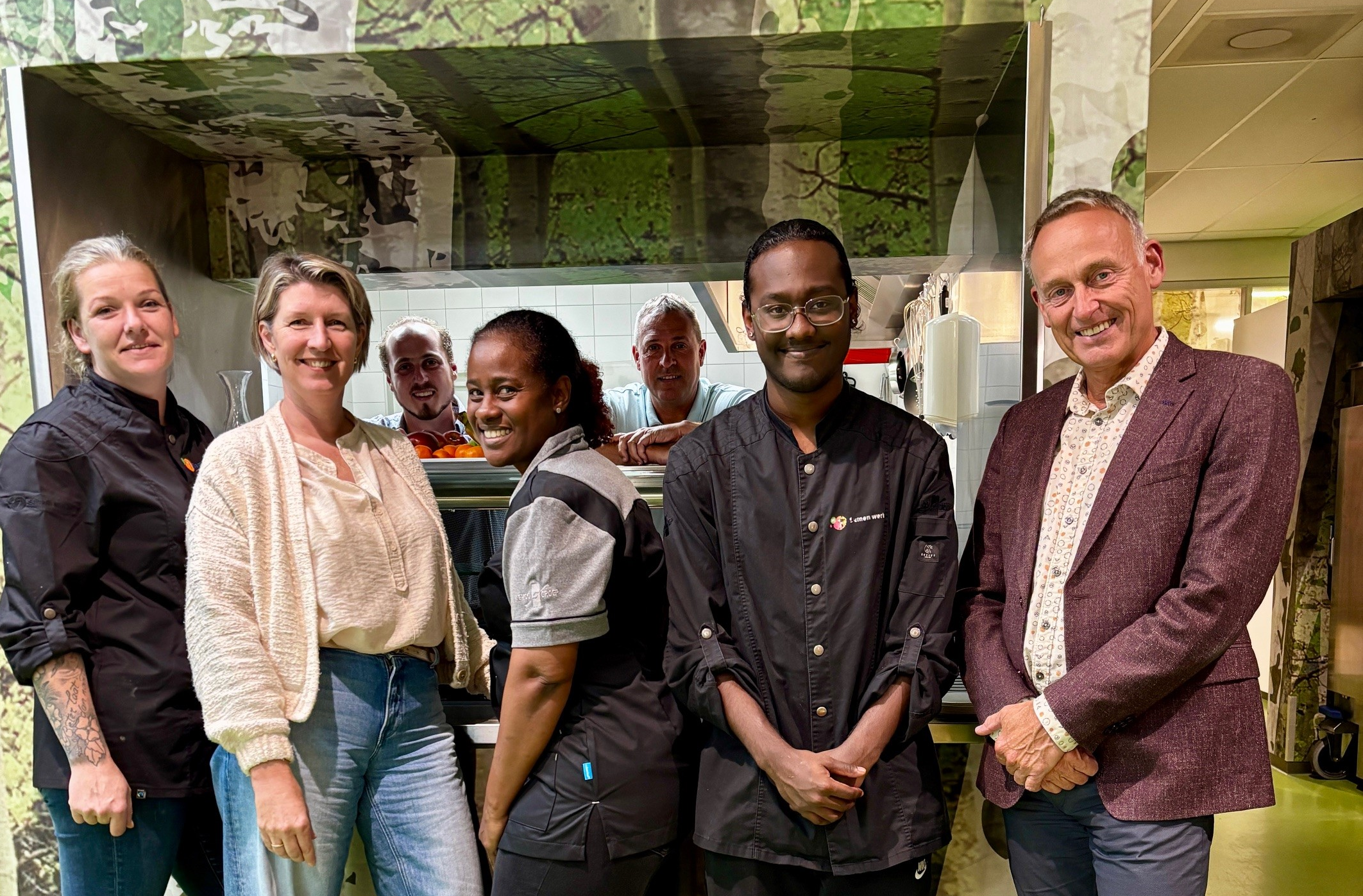 Foto bedrijfsrestaurant gemeente Emmen met Heidy Postma en wethouder Jan Bos en medewerkers
